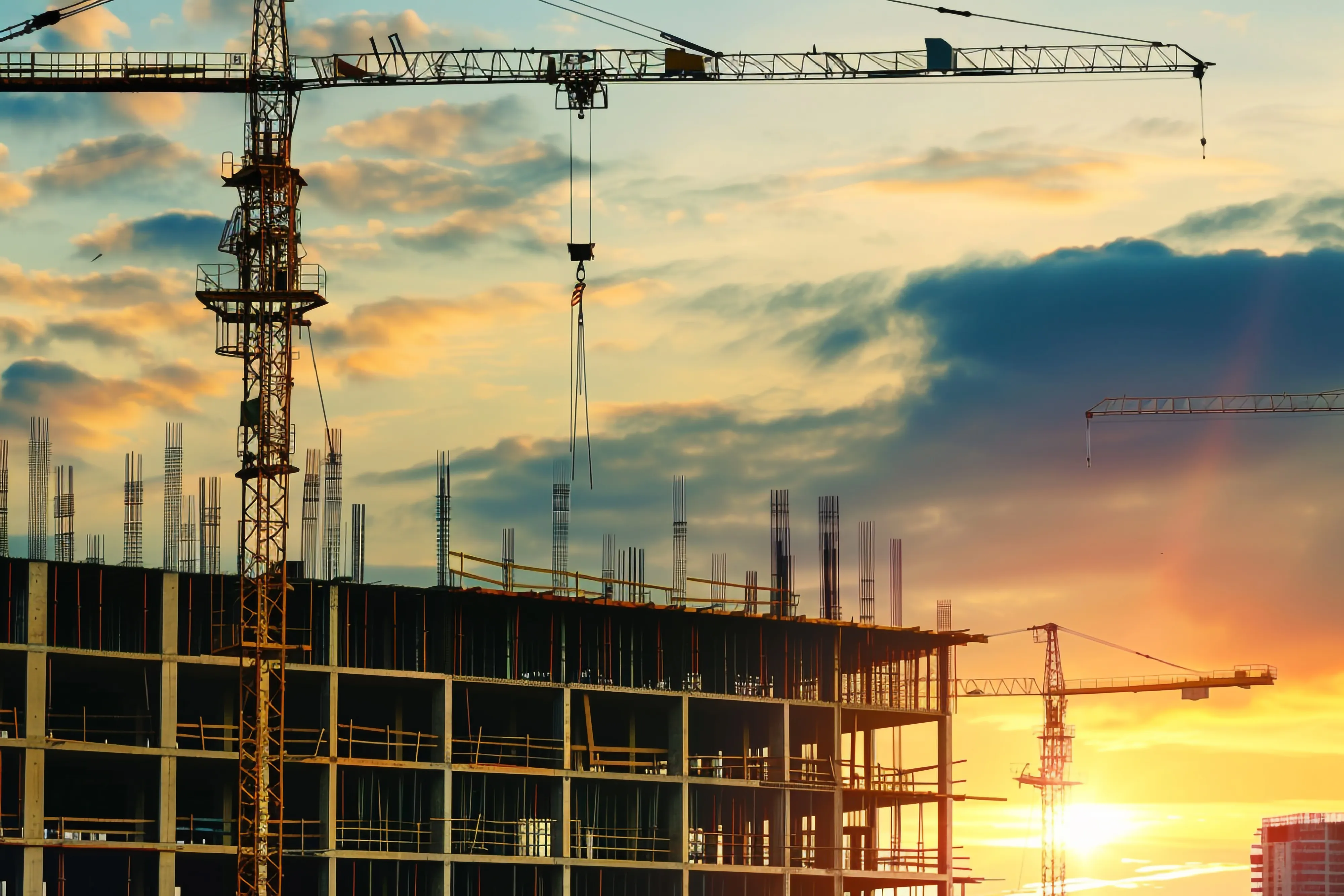 Construction site with cranes at sunset — civil and structural engineering